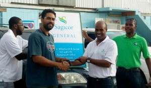 Operator of the Miniya’s supermarket chain, Hilkiah Lavinier is among the commercial clients having claims settled by Sagicor General. Here he receives a cheque from Sagicor General’s Assistant Vice-President of Claims, John Chandler 